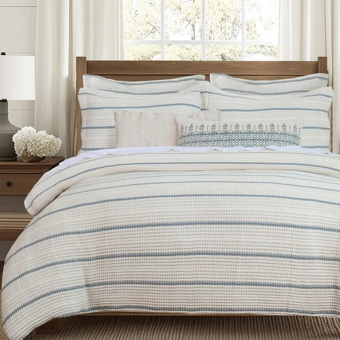 Front view of Waffle Stripe Blue Comforter Set with matching striped shams and decorative lumbar pillows in a bright neutral bedroom.