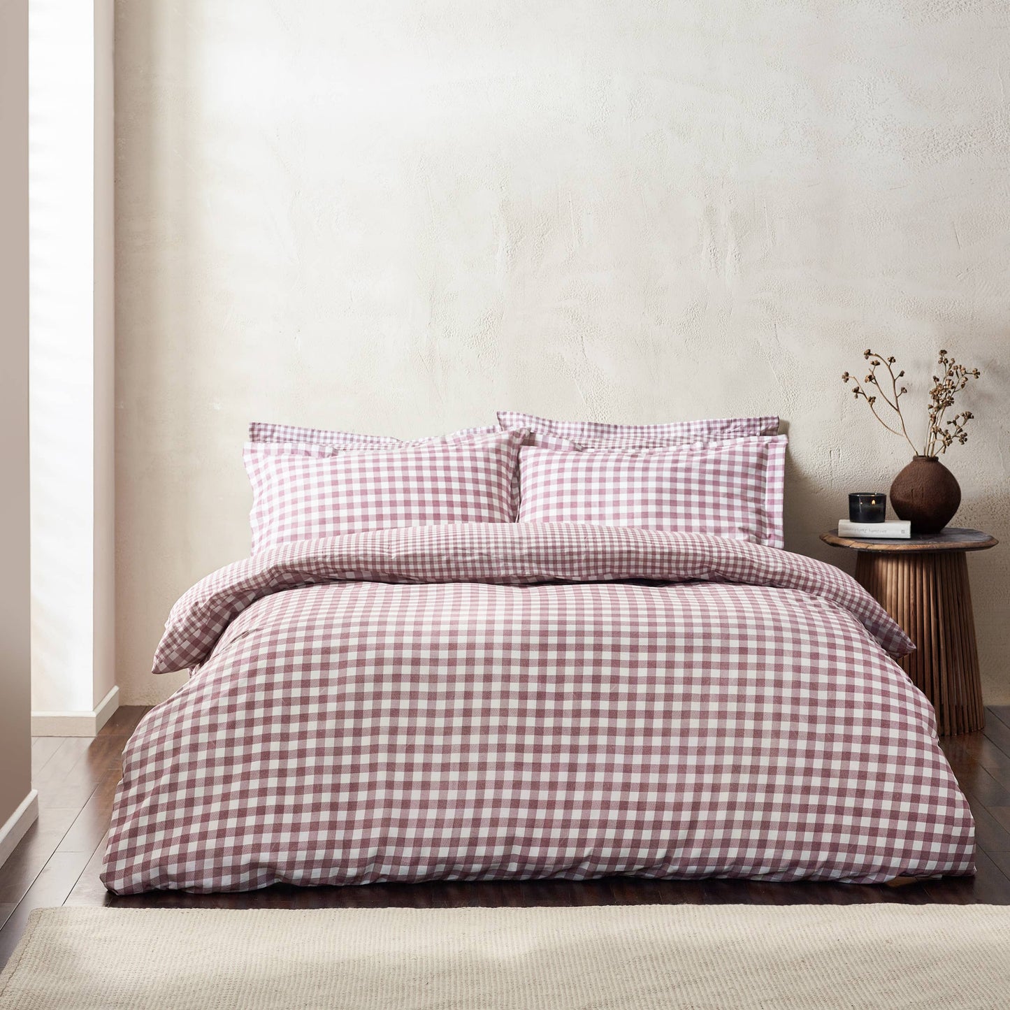 Bed with berry and white checkered bedding in a minimalistic bedroom setting