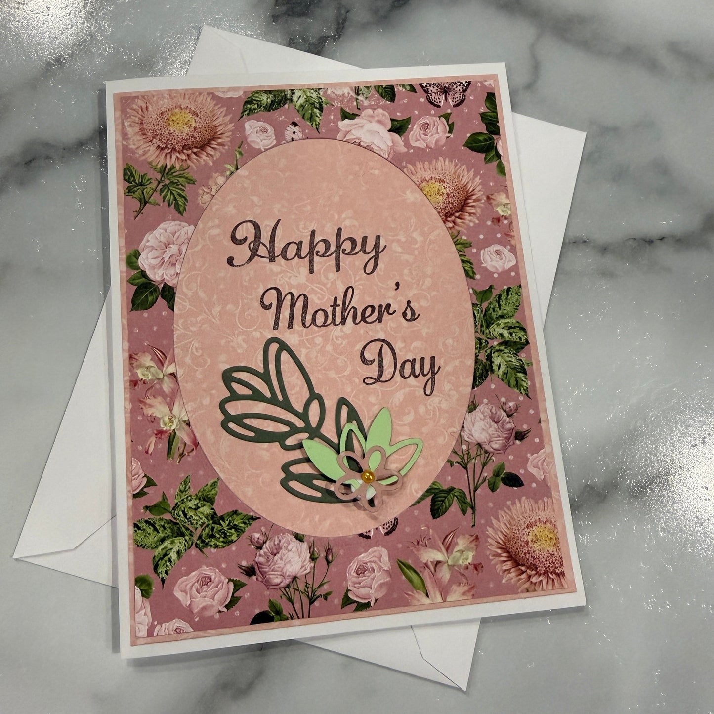 Greeting card with floral design and 'Mother's Day' text on a marble surface