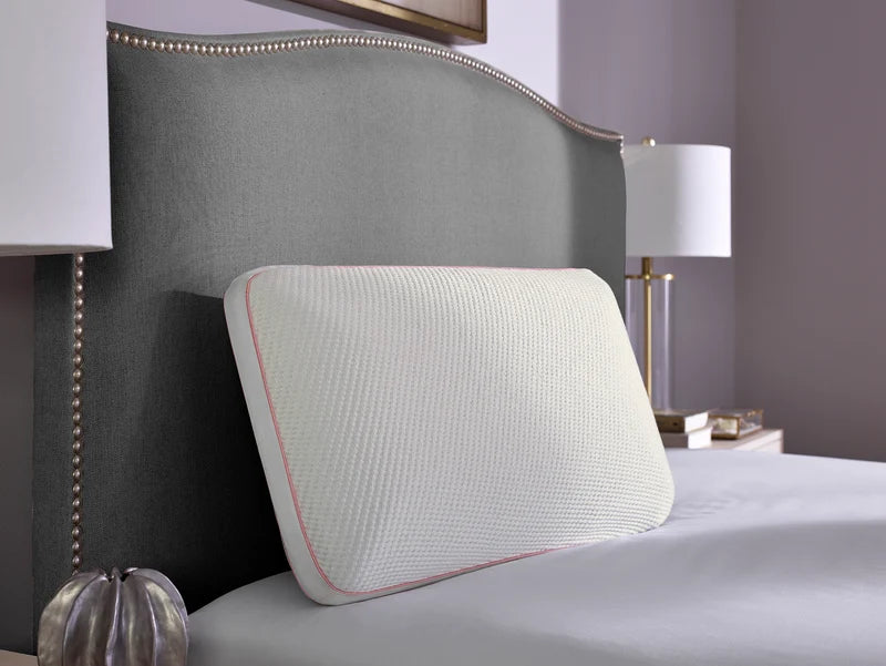Sleeptone LOFT Cool Control Pillow with textured white TENCEL cover and pink satin piping displayed against a gray upholstered headboard.