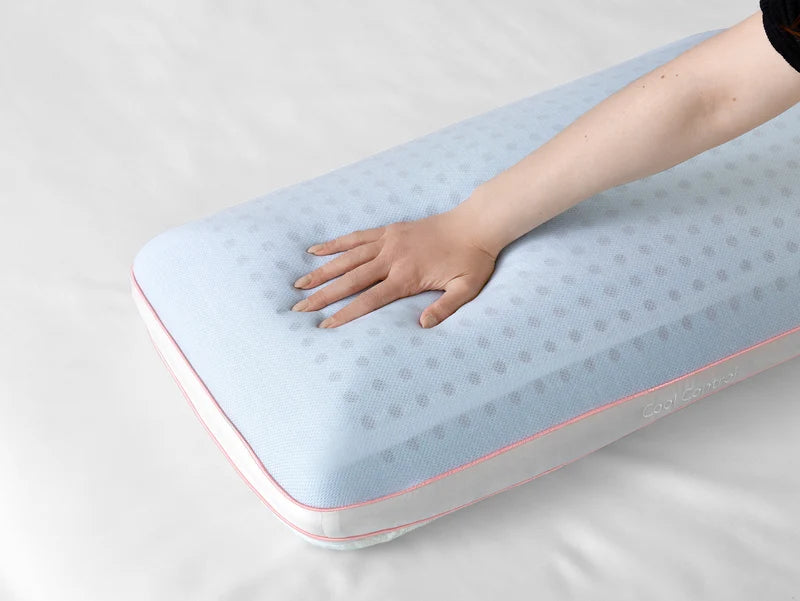 Hand pressing the light blue cooling surface of the Sleeptone LOFT Cool Control Pillow to demonstrate its cushioning and comfort.