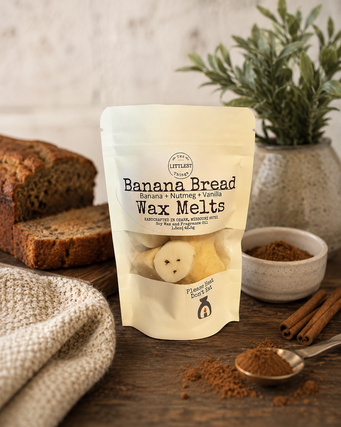 Packaging of Banana Bread wax melts on a wooden surface with banana bread and spices.